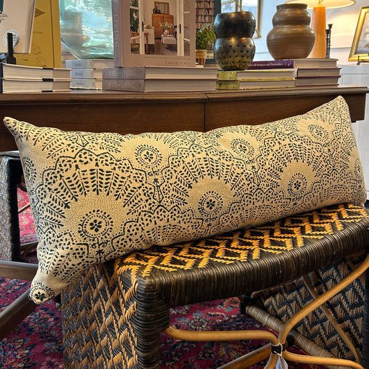 patterned long pillow on rattan stool